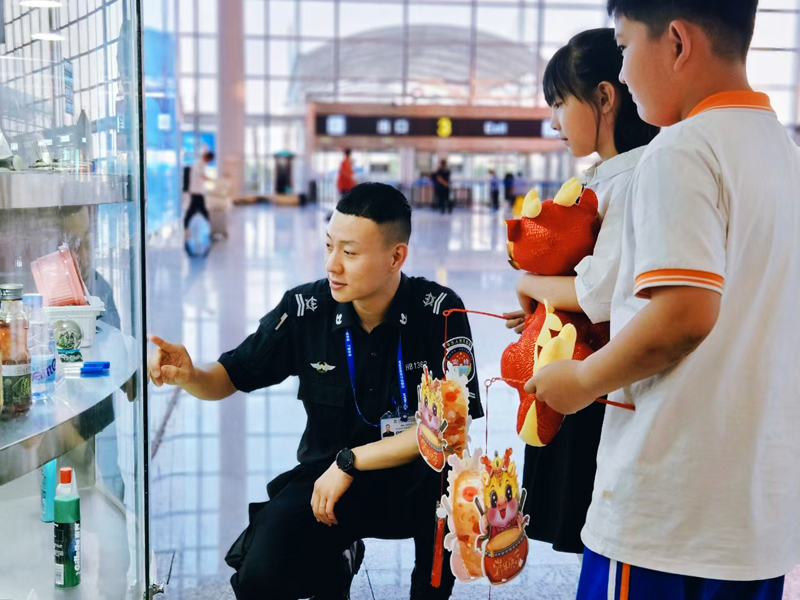 工作人員為小朋友講解哪些物品不能乘機(jī).jpg